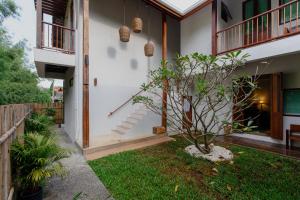 uma casa com uma pequena árvore no quintal em Foresta Villa em Hang Dong