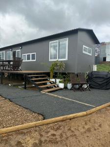 a house with a table and benches in front of it at Country Charm Cabins 2 Bedroom Tiny Home in Coolabunia