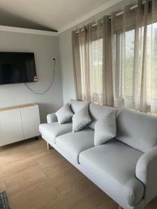 a living room with a couch and a flat screen tv at Country Charm Cabins 2 Bedroom Tiny Home in Coolabunia