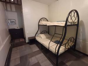 a small room with two bunk beds in it at Little John's Town Inn in Coron