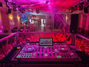 a room with a dj mixing board in a room with pink lights at Hotel Incognito in Jáchymov