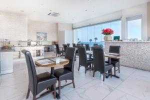 a dining room with tables and chairs and a kitchen at Achilleos City Hotel in Larnaca
