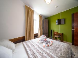 a bedroom with a bed with a stuffed animal on it at Hotel La Casa de la Abuela in Boquete +80 photos