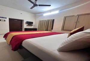a bedroom with a large bed with a ceiling fan at Hotel O Kurnool Railway Station Road in Kurnool