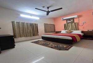 a bedroom with a bed and a ceiling fan at Hotel O Kurnool Railway Station Road in Kurnool