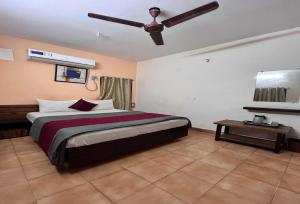 a bedroom with a bed and a ceiling fan at Hotel O Kurnool Railway Station Road in Kurnool