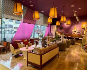 a restaurant with a couch and tables and chairs at BREEV GWANGJU by LOTTE HOTELS, formerly Ramada Plaza by Wyndham Gwangju in Gwangju