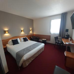 a hotel room with a large bed and a desk at Brit Hotel Confort Villeneuve Sur Lot in Bias