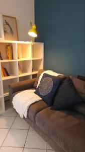 a brown couch sitting in a room with shelves at Apartment with a Mountain View in Lecco