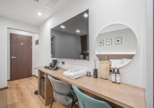 a room with a vanity with chairs and a mirror at Lantana Daegu Shinam Branch in Daegu