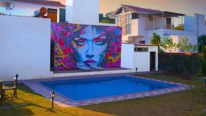 a painting on the side of a building with a pool at Goya Hills 3BHK - Private Villa Udaipur in Udaipur