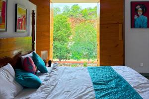 a bedroom with a bed with a large window at Goya Hills 3BHK - Private Villa Udaipur in Udaipur +11 photos