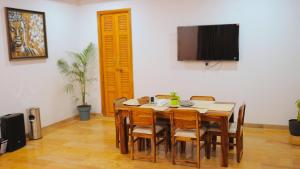 a dining room with a table with chairs and a flat screen tv at Goya Hills 3BHK - Private Villa Udaipur in Udaipur