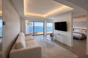 a living room with a couch and a bed and a television at Mediterranean Hotel in Rhodes Town