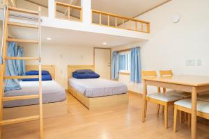 a bedroom with two bunk beds and a dining table at 森と湖の楽園 ドッグラン&バレルサウナ in Fujikawaguchiko