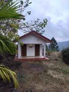 a small white house with a red roof at Lucknature Cabana Kandy in Elamalwewa