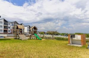 a playground with a slide and a swing at AlimamaSpaces The Lavender in Northriding