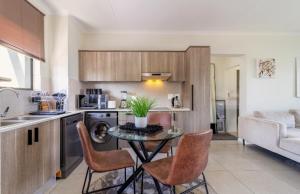 a kitchen with a table and chairs in a room at AlimamaSpaces The Lavender in Northriding