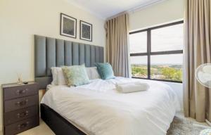 a bedroom with a large bed with a large window at AlimamaSpaces The Lavender in Northriding +23 photos