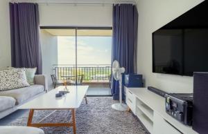 a living room with a couch and a tv at AlimamaSpaces The Lavender in Northriding