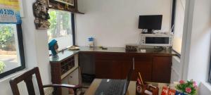a room with a desk with a computer and a microwave at Le Aham Boutique Hotel in Kuilapayam