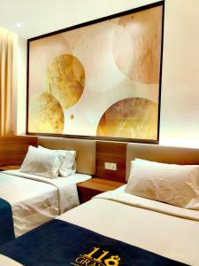 a hotel room with two beds and a painting on the wall at 118 Grand Hotel in George Town