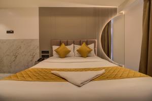 a bedroom with a large bed with yellow pillows at Hotel Malad Inn opposite Malad Railway Station in Mumbai