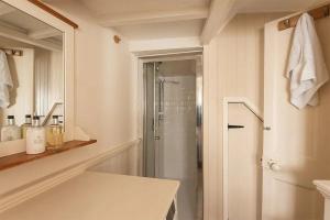 a white bathroom with a shower and a white counter at Homelands in Port Isaac +12 photos