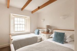 a bedroom with two beds and a window at Homelands in Port Isaac