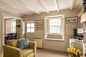 a living room with a chair and a window at Homelands in Port Isaac
