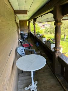 a table and chairs on the porch of a house at BnB Haus Itten in Hondrich