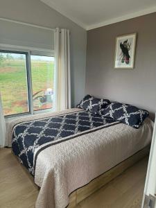 a bedroom with a bed and a window at Country Charm Cabins 2 Bedroom Tiny Home in Coolabunia