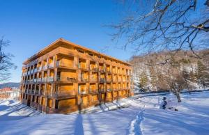a building in the snow with snow covered ground at Bakuriani valley Didveli in Bakuriani