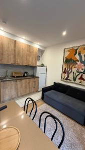 a living room with a couch and a table and chairs at Bakuriani valley Didveli in Bakuriani