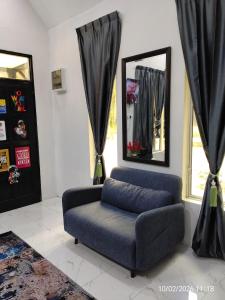 a living room with a chair and a mirror at Moksu Garden Tiny House jerteh in Jertih