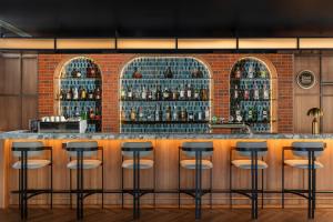 a bar with stools in front of a brick wall at Four Points by Sheraton Bangkok Ploenchit Sukhumvit in Bangkok