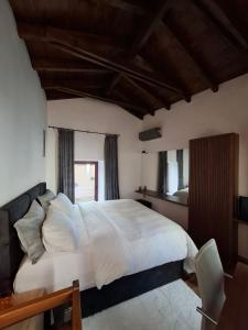 a bedroom with a large white bed and a window at Evanthia maisonette in Chalkida