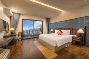 a bedroom with a large bed and a large window at DeLaMont Sapa Hotel - Hill Serenity Retreat in Sapa