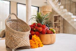 a basket of fruit on a table next to a basket of flowers at South Villa Ungasan in Ungasan