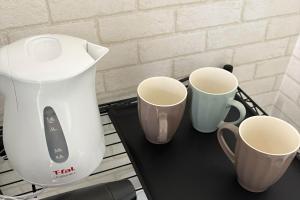 three cups of coffee sitting on top of a stove at シーシャイン北金沢 102号室 in Aomori