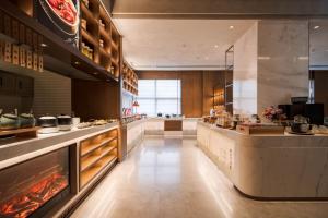 a large kitchen with a counter in a restaurant at Atour Hotel Dalian Development Zone in Dalian