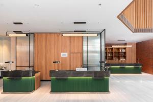 a lobby with two counters and a glass wall at Four Points by Sheraton Bangkok Ploenchit Sukhumvit in Bangkok