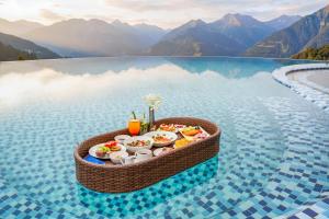 a tray of food on a table in a pool of water at DeLaMont Sapa Hotel - Hill Serenity Retreat in Sapa