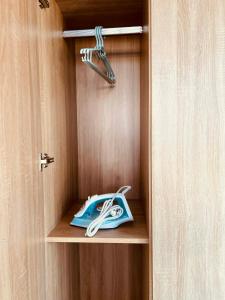 a wooden cabinet with a hanger and a telephone at GreenHotel in Ban M'drack