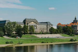 a large building next to a body of water at Dresden Rooftop Apartment mit 2 Balkone, Stellplatz, Top Anbindung in Dresden