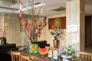 a table with chairs and flowers on it at Gold Central Hotel by Haviland in Danang