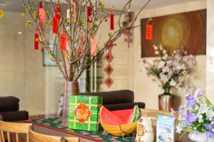 a table with a vase with watermelons on it at Gold Central Hotel by Haviland in Danang