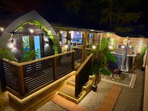 a house with a deck at night with lights at The Secret Garden Glamping Cornwall in Cury