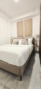 a bedroom with a large bed with white sheets and pillows at Nala Host-Luxor studios in Male City
