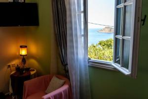 a window in a room with a chair and a window with a view at Melina's sunset-Cozy studio with amazing sea view and sunset in Myrties